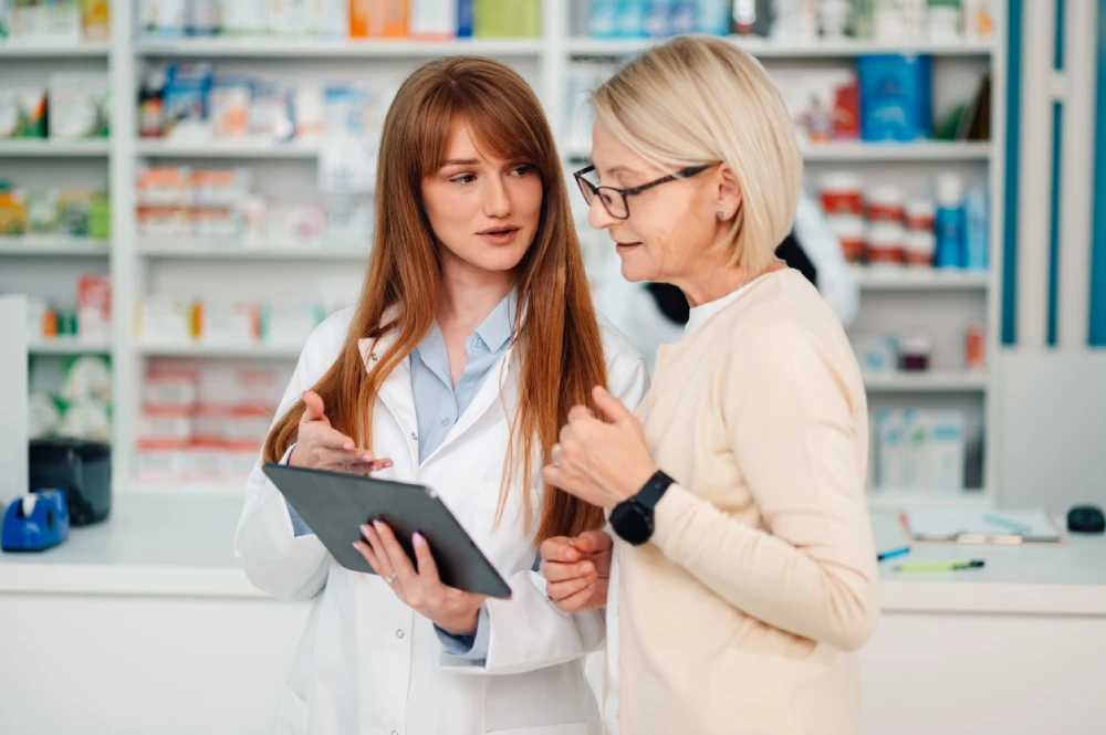 pharmacist showing a patient their digital pharmacy tools on a tablet 