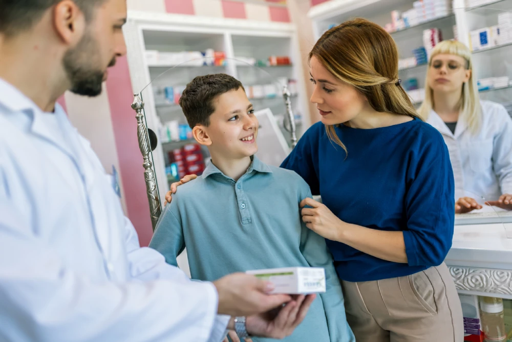 a pharmacist talking to a mother and her son