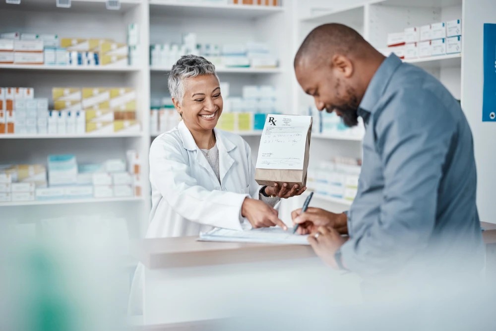 pharmacist handing a man his prescription