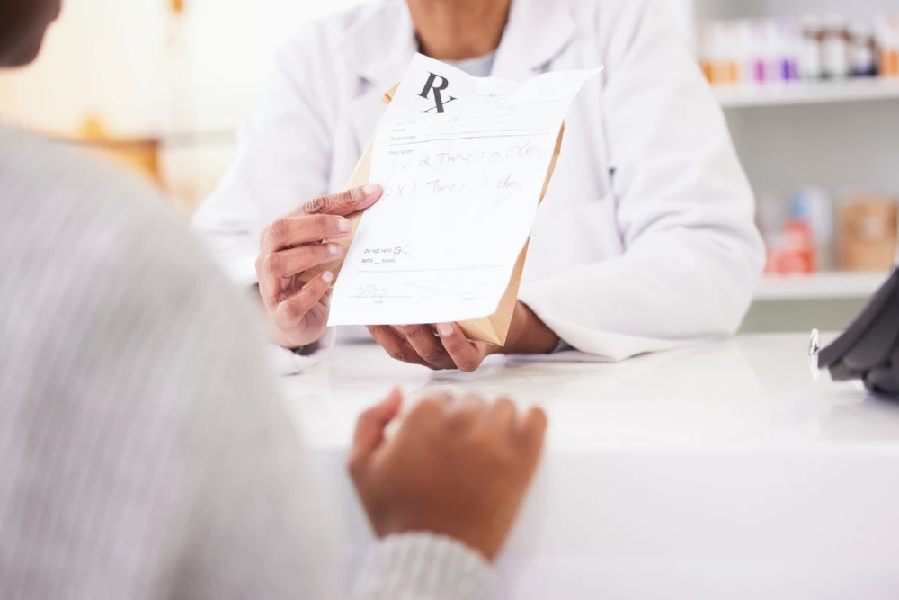 pharmacist passing a prescription bag to a client - supporting healthy pharmacy profits