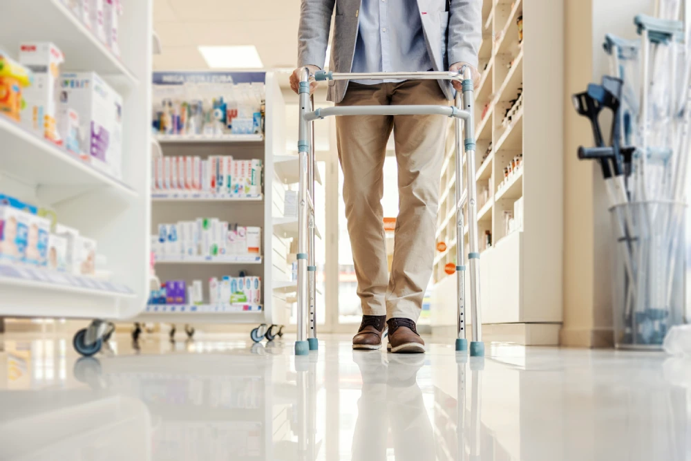 man using a walker in a pharmacy - the importance of pharmacy layout for accessibility