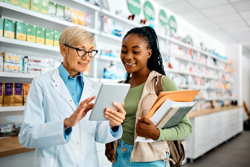 pharmacist showing customer their pharmacy loyalty program for store products