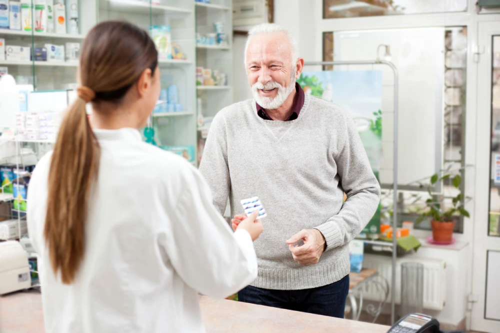 pharmacist assisting older man with his prescription using best pharmacy practices