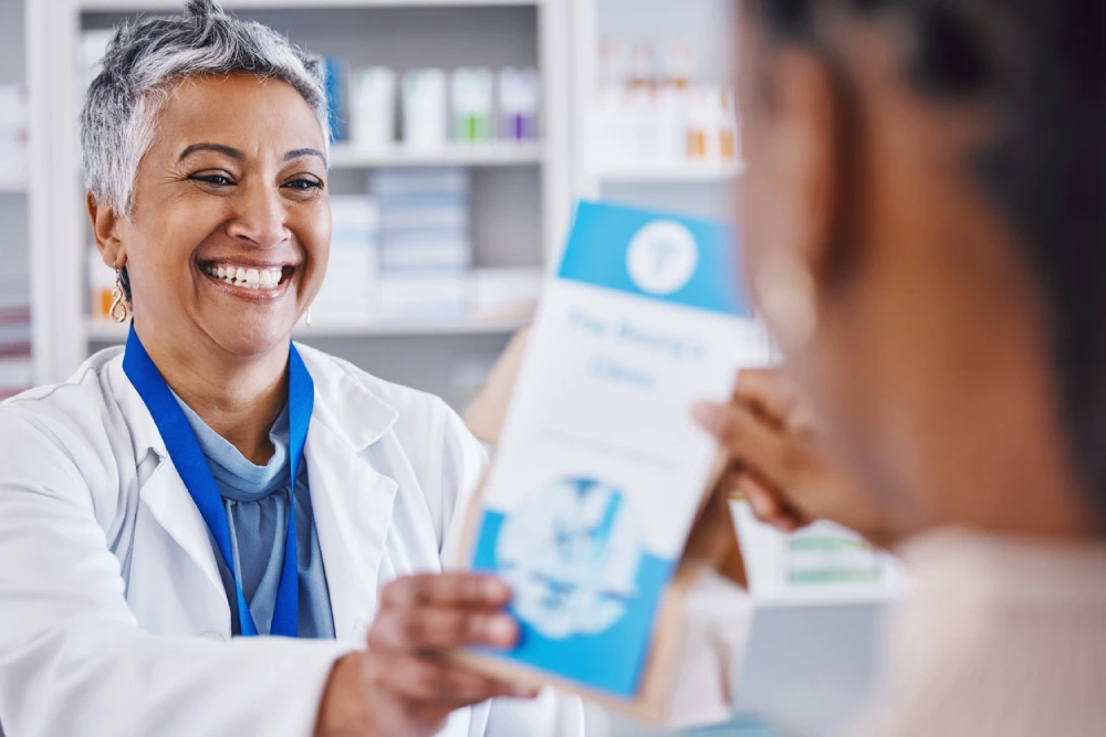 local pharmacy owner handing prescription to patient