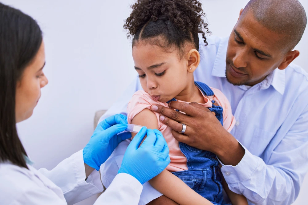 local pharmacist putting a bandaid on a child's arm - local pharmacy services