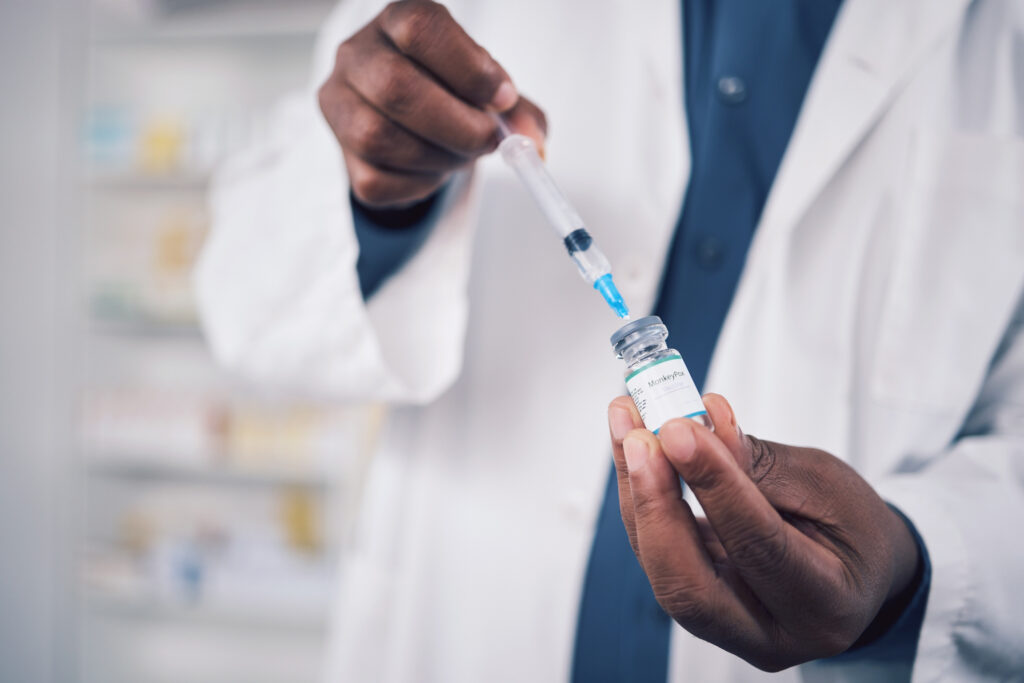 A pharmacist's hands are preparing an immunization.