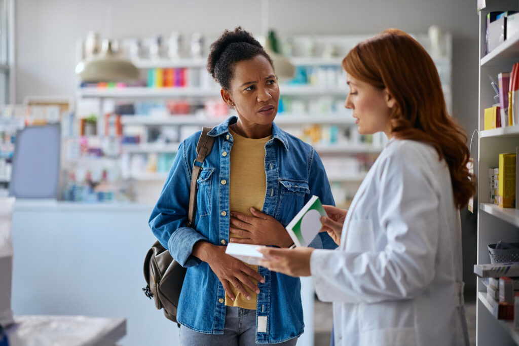 A female pharmacist counsels a young woman.